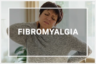 A middle aged woman holds her back and neck, displaying signs of pain