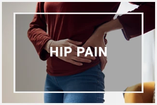 A woman clutches her hip in pain while trying to stand upright