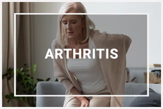 An older woman struggling to stand from the couch because of the arthritis pain in her back