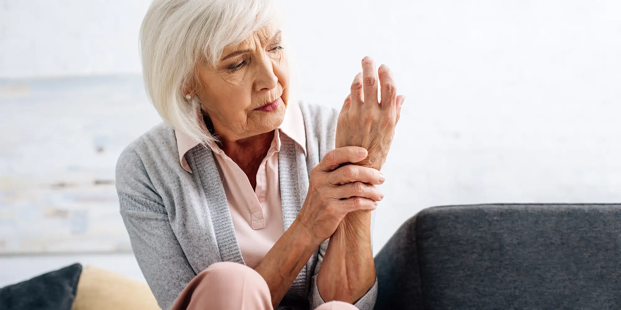 Physical Medicine Columbus GA Person With Arthritis Pain Senior Woman With Arthritis Pain holding her wrist and looking at it dejectedly