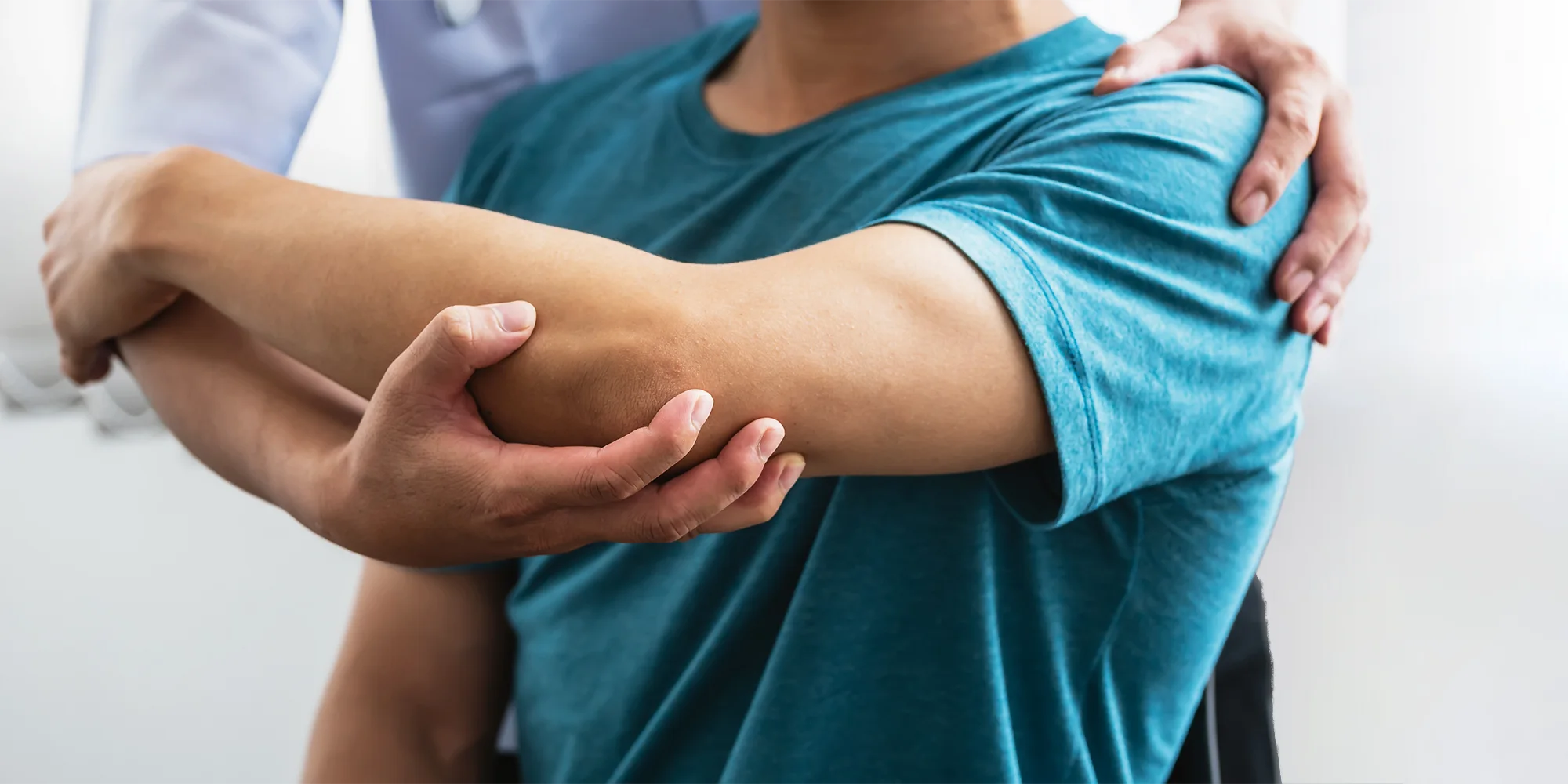 Physical Medicine Columbus GA Person With Elbow Pain Person With Elbow Pain being assisted by a doctor, manually moving their arm